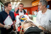 Dr. Haase (Fabian Harloff, l.) bringt Dr. B&auml;umer (Roland Kieber, r.) einen Patienten mit schweren Kopfverletzungen.