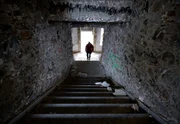 Man walking the stairs of an abandoned spooky hotel building.