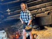 Almerer Lukas Moser zeigt frisch gemachte Kasnocken in gusseisernen Pfanne