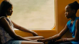 Marieme (l, Karidja Tour&eacute;) und ihre Schwester B&eacute;b&eacute; (Simina Soumar&eacute;) fahren mit dem Zug nach Hause.