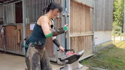 Hufschmiedin Bettie schlägt ein Hufeisen zurecht. Hufschmiedin Bettie schlägt ein Hufeisen zurecht.