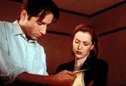 Mulder (David Duchovny, l.) und Scully (Gillian Anderson, r.) besch&auml;ftigen sich mit einer Mordserie, bei der &Auml;rzte einer Sch&ouml;nheitsklinik in einem Anfall geistiger Umnachtung ihre Patienten brutal umbringen.