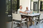 Hausbesitzer lachen und essen auf dem Balkon Hausbesitzer lachen und essen auf dem Balkon