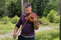 Geigenbauer Rubino Gabrielli probiert seine Geige im Resonanzwald aus.