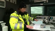 Polizeihauptmeisterin Anja K&ouml;pcke &uuml;berpr&uuml;ft die Papiere eines angehaltenen LKW-Fahrers.