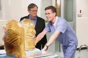 K&ouml;nnen sie dem Mechanismus der t&ouml;dlichen "Schutz"westen auf die Spur kommen? Dr. Mallard (David McCallum, l.) und Palmer (Brian Dietzen, r.) ...