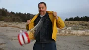 Host Josh Gates opens his jacket revealing toy dentures like Data from The Goonies Host Josh Gates opens his jacket revealing toy dentures like Data from The Goonies