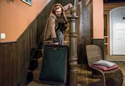 Johanna (Brigitte Antonius) versucht, ihren Koffer alleine die Rosenhaustreppe hochzuwuchten. Dabei verliert sie das Gleichgewicht und stürzt … Johanna (Brigitte Antonius) versucht, ihren Koffer alleine die Rosenhaustreppe hochzuwuchten. Dabei verliert sie das Gleichgewicht und stürzt …
