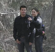 Booth (David Boreanaz, L) and Brennan (Emily Deschanel, R) find strange clues while investigating the murder of a student in the BONES episode "The Headless Witch in the Woods".