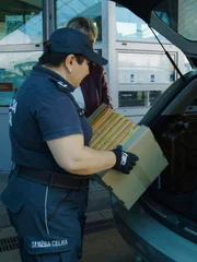 Der Grenzbeamte kontrolliert den Inhalt des Kofferraums. Der Grenzbeamte kontrolliert den Inhalt des Kofferraums.