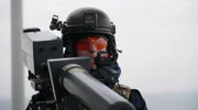 Eine Soldatin zielt mit einem Drone-Buster auf eine Drohne Eine Soldatin zielt mit einem Drone-Buster auf eine Drohne