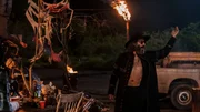 Der Prediger der Heiligen Männer (Jason Mantzoukas) fordert seine Anhänger auf, als Götter der Straßen über das Chaos zu herrschen – und ihm Gaben zu überreichen. Der Prediger der Heiligen Männer (Jason Mantzoukas) fordert seine Anhänger auf, als Götter der Straßen über das Chaos zu herrschen – und ihm Gaben zu überreichen.