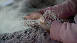 Die H&auml;nde eines Fischers, der sein Fischernetz repariert