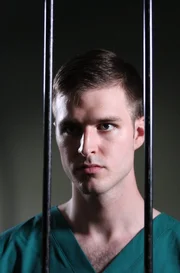 Larry Ranes looking through jail cell bars. Larry Ranes looking through jail cell bars.