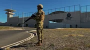 Ein Wachmann steht vor dem Eingang des Centro de Confinamiento del Terrorismo (CECOT) in El Salvador.