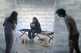 Ein Student (Yeon-Seok, Mi.) der Akademie bei der Ausstellung seiner Performance-Installation: In einem schmelzenden Iglu aus Eisbl&ouml;cken harrt er auf einer Pritsche aus.