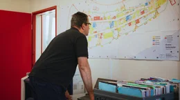Kirmeschef Sven Gerling begutachtet den Aufbauplan der D&uuml;sseldorfer Rheinkirmes 2025 in seinem B&uuml;rocontainer.