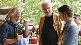 Georg (G&uuml;nther Maria Halmer, M.) nimmt Sofia (Senita Huskić, re.) mit auf den Markt. Dort kauft er seit Jahrzehnten bei Francois (Tony De Maeyer, li.) ein.
