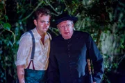 Sid (Alex Price, l.) und Father Brown (Mark Williams, r.) verstecken sich im Wald. Sie beobachten die Dorfbewohner, die sich um einen Stein versammelt haben, um ein geheimes Ritual zu vollziehen. Sid (Alex Price, l.) und Father Brown (Mark Williams, r.) verstecken sich im Wald. Sie beobachten die Dorfbewohner, die sich um einen Stein versammelt haben, um ein geheimes Ritual zu vollziehen.