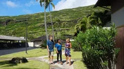 Home buyers Nalani Kuglin, Matthew Kuglin, and realtor Jodi Mews walking outside Keokea house as seen on Hawaii Hunters (Action)