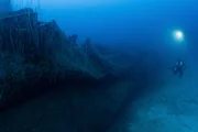 Taucher untersuchen die geschmolzenen und zerknitterten &Uuml;berreste des Rumpfes der USS Gilliam.