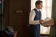 Inspector Sullivan (Tom Chambers) sieht die Ermittlungsakte durch.