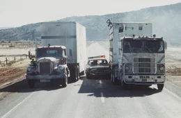 Die aufgebrachten Trucker lassen sich von nichts in ihrem Convoy stoppen: Und was kann ein winziges Polizeiauto auch gegen die riesigen PS-Boliden schon anrichten ...