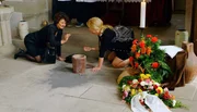 Bei der Pr&uuml;gelei ist die Urne mit der Asche des Verstorbenen zu Boden gefallen. Elisabeth (Franziska K&uuml;pferle) und Nana Meyer (Lea Nacken) sammeln sie so gut wie m&ouml;glich wieder ein und wundern sich, was sie zwischen der Asche so alles finden.