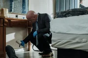 Detective Michael Moran h&auml;lt eine Kaffeetasse als Beweisst&uuml;ck. (Szene nachgestellt)