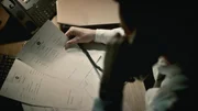 Mann telefoniert und sieht Dokumente an.