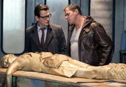 Finn Kiesewetter (Sven Martinek, r.) und Lars Englen (Ingo Naujoks, l.) stehen vor einem R&auml;tsel. Welches Motiv hatte der T&auml;ter, die Gesch&auml;ftsf&uuml;hrerin einer Lackfabrik (Antonia Gerke, v.) zu t&ouml;ten und mit goldener Farbe zu bespr&uuml;hen?