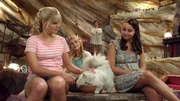 Sirena (Amy Ruffle), Lyla (Lucy Fry) und Nixie (Ivy Latimer, v. li. n. re.) geben Kater Poseidon sein Futter. Rita (Kerith Atkinson, im Hintergrund) freut sich. Sirena (Amy Ruffle), Lyla (Lucy Fry) und Nixie (Ivy Latimer, v. li. n. re.) geben Kater Poseidon sein Futter. Rita (Kerith Atkinson, im Hintergrund) freut sich.