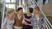 Sirena (Amy Ruffle, li.), Nixie (Ivy Latimer, 3.v.li.) und Lyla (Lucy Fry, re.) begleiten Rita (Kerith Atkinson, 2.v.li.) in ihr B&uuml;ro. Sie f&uuml;hlt sich aus unerfindlichen Gr&uuml;nden sehr schwach.