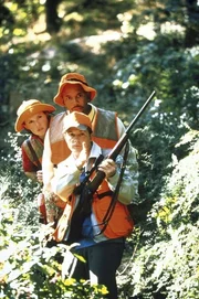 Vorsichtig pirschen sich (v.l.n.r.) Nikki (Connie Britton), Carter (Michael Boatman) und Mike (Michael J. Fox) mit einem Gewehr durch den Wald. Vorsichtig pirschen sich (v.l.n.r.) Nikki (Connie Britton), Carter (Michael Boatman) und Mike (Michael J. Fox) mit einem Gewehr durch den Wald.