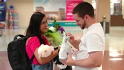 Clayton and Anali laugh with each other as he pulls out another gift for her at the airport in Kentucky. Clayton and Anali laugh with each other as he pulls out another gift for her at the airport in Kentucky.