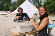 Tobi mit Beachvolleballerin Tatjana. Tobi soll den Fisch im Sand versinken lassen - ohne zu graben und ohne zu drücken. Tobi mit Beachvolleballerin Tatjana. Tobi soll den Fisch im Sand versinken lassen - ohne zu graben und ohne zu drücken.