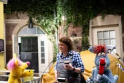 Woozle (re.) hat Woonie versprochen, mit ihr campen zu gehen. Aber nun kriegt er kalte Füße. Also lässt sich Woonie überreden, dass die beiden im Hof von Simóns Wohnhaus campen. Das verstößt aber gegen die Hausordnung, meckert Frau Blume (Dagmar Sachse). Woozle (re.) hat Woonie versprochen, mit ihr campen zu gehen. Aber nun kriegt er kalte Füße. Also lässt sich Woonie überreden, dass die beiden im Hof von Simóns Wohnhaus campen. Das verstößt aber gegen die Hausordnung, meckert Frau Blume (Dagmar Sachse).