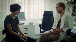 Jona (Naomi Achternbusch) will vom Augenarzt (Robert Gwisdek) wissen, ob es vor&uuml;bergehende Blindheit gibt.