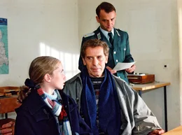 Rolf (Roland Sch&auml;fer) und Lilly (Cornelia Gr&ouml;schel) holen das Besuchervisum auf der Polizeidienststelle ab.Polizist im Hintergrund: Unterleutnant (Gerd Beyer).