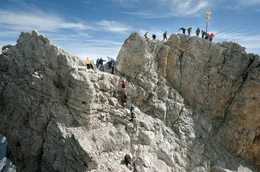 Das Gipfelkreuz der Zugspitze auf 2.962 Meter H&ouml;he wird von Besuchern gerne mit Aufklebern beklebt &ndash; und muss alle paar Jahre zur Reinigung und Restaurierung ins Tal geflogen werden.