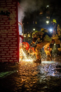 Silvester in Berlin: Schon am fr&uuml;hen Abend bereiten sich die Einsatzkr&auml;fte der Berliner Feuerwehr auf eine 12-st&uuml;ndige Ausnahmeschicht vor. Dieser Film begleitet Profis und Freiwillige von drei Berliner Feuerwachen durch diese au&szlig;ergew&ouml;hnliche Nacht. - Die Freiwillige Feuerwehr der Wache Suarez l&ouml;scht einen brennenden Kleidercontainer.