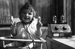 Radio ist in aller Ohren &ndash; und das seit 100 Jahren: Am 29. Oktober 1923 geht dieses Massenmedium &bdquo;on air&ldquo;. Aber der &bdquo;Rundfunk&ldquo; sorgte nicht nur f&uuml;r den Soundtrack der Geschichte und Unterhaltung, sondern er war immer auch ein Machtinstrument. Der Film ist ein radiophones Roadmovie durch Zeit und Raum. Er erz&auml;hlt anhand bewegender Tondokumente 100 Jahre Radiogeschichte als deutsche Zeitgeschichte. - Anf&auml;nge der Radio&uuml;bertragung - Kind mit Kopfh&ouml;rern am Radio, 1925.