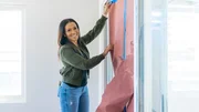 As seen on HGTV’s Fix My Flip, host Page Turner removes all the paper and tape placed over the windows that the painters left behind. As seen on HGTV’s Fix My Flip, host Page Turner removes all the paper and tape placed over the windows that the painters left behind.