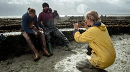 Lissi (Morgane Ferru) dokumentiert die Austernzucht mit den Arbeitern Briac (Guillaume Thierry) und Jean (Liliom Lewald, li.).