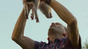 Andi Knuppe (Milan Peschel) hebt sein Hausschwein Babe in die Höhe. Für ihn ist klar: Babe gehört zur Familie – und nicht auf den Grill. Andi Knuppe (Milan Peschel) hebt sein Hausschwein Babe in die Höhe. Für ihn ist klar: Babe gehört zur Familie – und nicht auf den Grill.