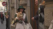 Mailänder Chic: Eine elegant gekleidete Frau mit Schoßhund vor einer Boutique. Mailänder Chic: Eine elegant gekleidete Frau mit Schoßhund vor einer Boutique.