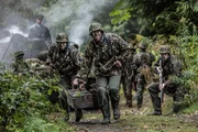 REENACTMENT &ndash; Angeh&ouml;rige der 2. Panzerdivision tragen eine Kiste mit Granaten, um sich auf einen Angriff vorzubereiten. (Bildnachweis: HLS6 Productions Ltd./Sean F. White)