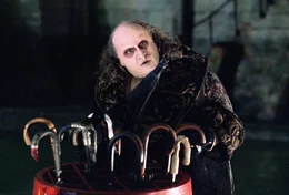 Sein Gegenspieler, Oswald Chesterfield, der Pinguin-Mann (Danny DeVito). Weil seine Gestalt seltsam missraten war, wurde er als Baby von seinen Eltern ausgesetzt, und wuchs in den Abw&auml;sserkan&auml;len Gothams auf.