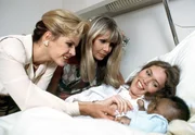 Anja (Andrea Heuer, re.) zeigt Krista (Julia Kent, li.) und Ulla (Christine Schuberth) stolz ihr Baby.