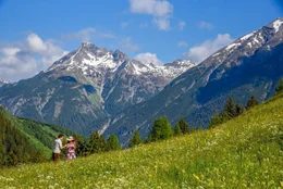 Elfi (Sofia Falzberger) und Sepp (Roland Silbernagl) spazieren auf der Bergwiese.